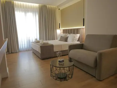 a living room with a couch and a bed at JKB Panoramic Suites in Athens