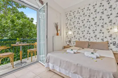 a bedroom with a bed and a balcony at Salver Stays in Athens
