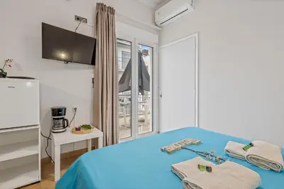 a bedroom with a blue bed and a window at Salver Stays in Athens
