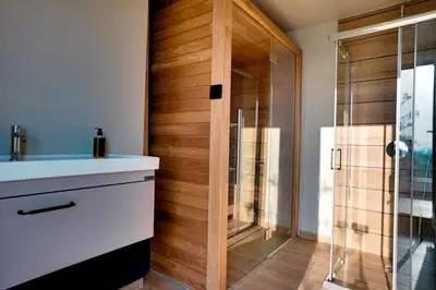 a bathroom with a shower with a wooden wall at Skyline Spa Athens 130 B in Athens