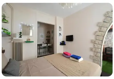 a room with a bed and a living room with a mirror at Cute apartment Center of Athens Petralona station in Athens