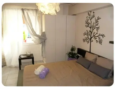 a bedroom with a large bed and a window at Cute apartment Center of Athens Petralona station in Athens