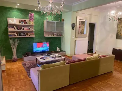 a living room with a couch and a tv at In the heart of Athens! Panoramic view of the Acropolis! in Athens