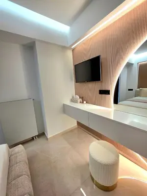 a hotel room with a couch and a tv on a wall at N K Suite - Design Boutique Stay with City view in Athens