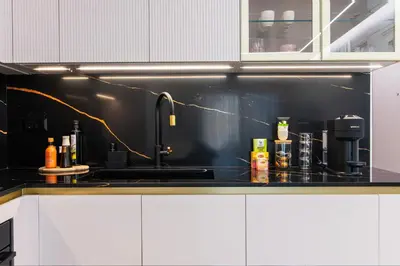a kitchen with a sink and a black wall at N K Suite - Design Boutique Stay with City view in Athens
