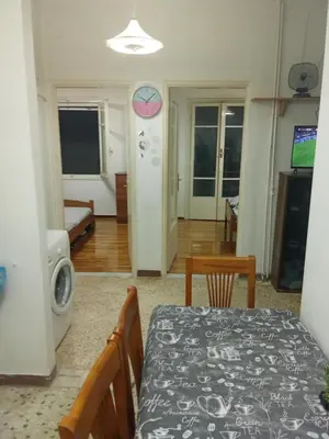 a dining room with a table and chairs and a kitchen at George's home in Piraeus