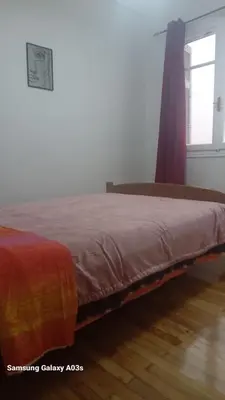 a bed sitting in a room with a window at George's home in Piraeus