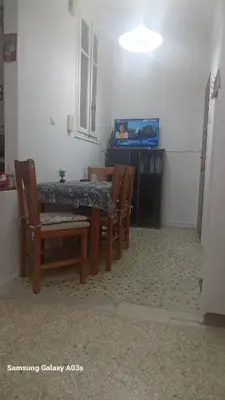 a dining room with a table and chairs and a television at George's home in Piraeus