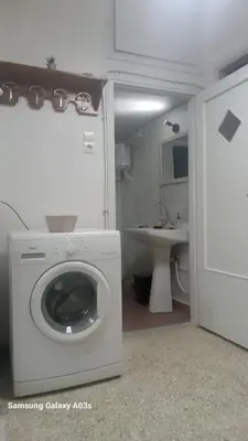 a washing machine in a bathroom with a sink at George's home in Piraeus