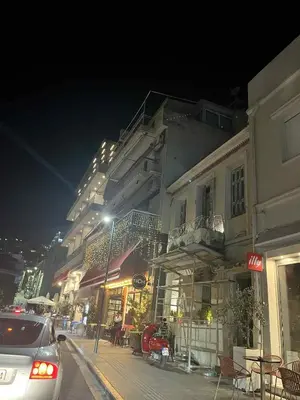 a car driving down a city street at night at George's home in Piraeus