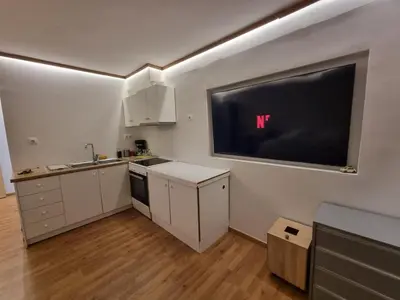 a kitchen with a flat screen tv on the wall at Loft apartment by the sea in Athens