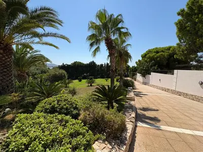 a garden with palm trees and a sidewalk at Summer villa Levon in Lagonissi