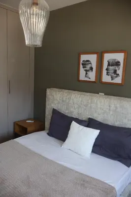 a bedroom with a bed with blue and white pillows at Athenean Coastal Getaway in Athens