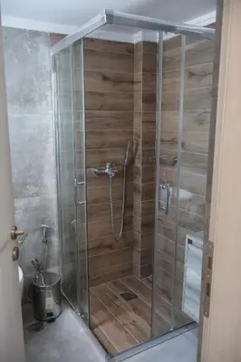 a shower with a glass door in a bathroom at Athenean Coastal Getaway in Athens