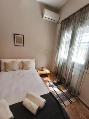 a bedroom with a white bed and a window at Flya House in Athens