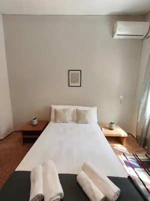 a bedroom with a large white bed with towels on it at Flya House in Athens