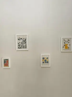 a wall with four pictures on a white wall at Flya House in Athens