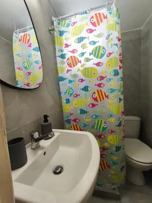 a bathroom with a sink and a shower curtain at Flya House in Athens