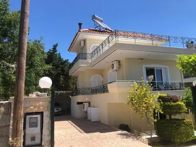 a white house with a balcony on top of it at 1 Bed Apartment near the beach in Aghia Marina