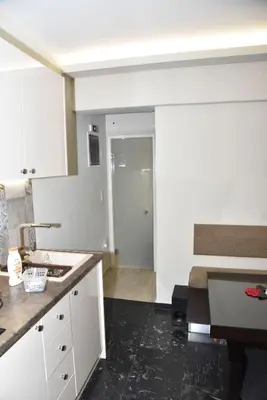 a kitchen with white cabinets and a black floor at Your Ideal Retreat in the Heart of Kallithea in Athens