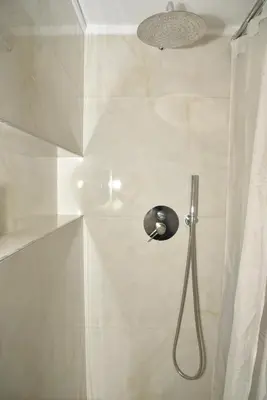 a shower with a shower head in a bathroom at Your Ideal Retreat in the Heart of Kallithea in Athens