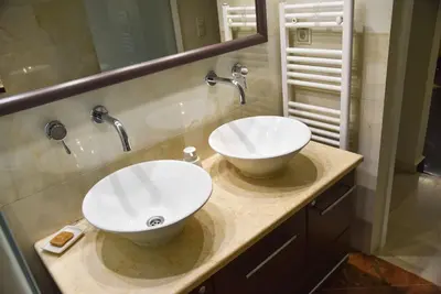 a bathroom with two white sinks on a counter at Your Ideal Retreat in the Heart of Kallithea in Athens