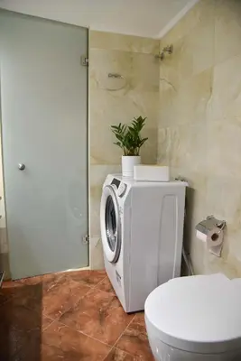 a bathroom with a toilet and a washing machine at Your Ideal Retreat in the Heart of Kallithea in Athens