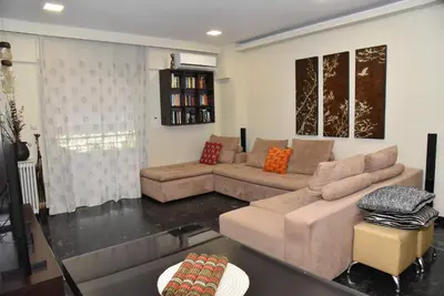 a living room with a couch and a table at Your Ideal Retreat in the Heart of Kallithea in Athens