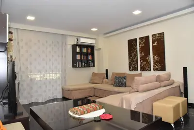 a living room with a couch and a table at Your Ideal Retreat in the Heart of Kallithea in Athens