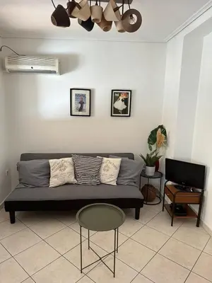 a living room with a couch and a table at Konstantina's Cozy central place to enjoy Athens in Athens