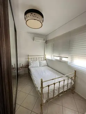 a bed in a room with a window and a lamp at Konstantina's Cozy central place to enjoy Athens in Athens