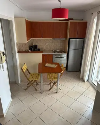 a kitchen with a table and chairs and a refrigerator at Konstantina's Cozy central place to enjoy Athens in Athens