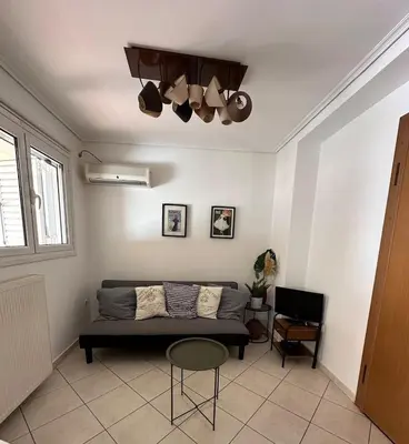a living room with a couch and a table at Konstantina's Cozy central place to enjoy Athens in Athens