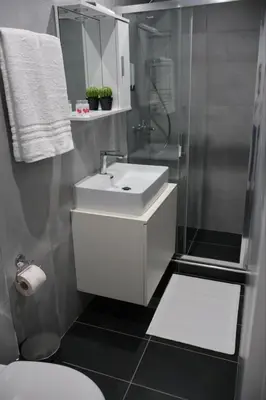 a bathroom with a white sink and a shower at Athenean Porto Piraeus Suites -GF1 in Piraeus