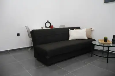 a black couch in a room with a table at Athenean Porto Piraeus Suites -GF1 in Piraeus