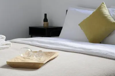 a pair of glasses on a wooden tray on a bed at Athenean Porto Piraeus Suites -GF1 in Piraeus