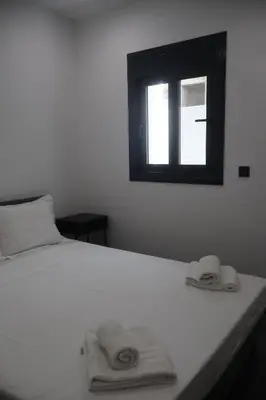 a bedroom with a white bed with towels on it at Athenean Porto Piraeus Suites -GF2 in Piraeus