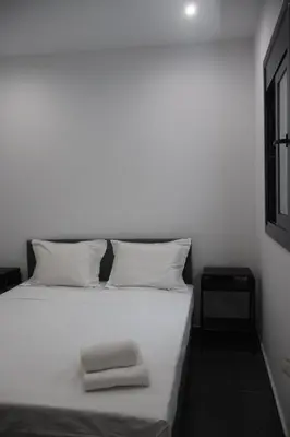 a white bed with two towels on top of it at Athenean Porto Piraeus Suites -GF2 in Piraeus