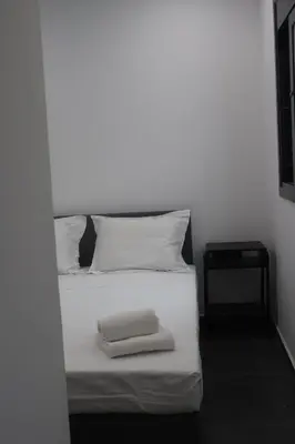 a white bed with two towels on top of it at Athenean Porto Piraeus Suites -GF2 in Piraeus