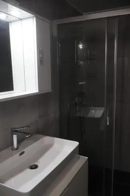 a bathroom with a sink and a glass shower at Athenean Porto Piraeus Suites -GF2 in Piraeus
