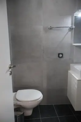 a bathroom with a toilet and a shower and a sink at Athenean Porto Piraeus Suites -GF2 in Piraeus