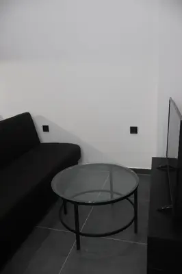 a glass coffee table in front of a black couch at Athenean Porto Piraeus Suites -GF2 in Piraeus