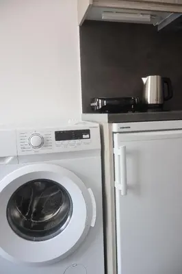 a kitchen with a washing machine and a counter at Athenean Porto Piraeus Suites -A1 in Piraeus