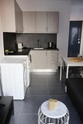 a kitchen with a sink and a table in a room at Athenean Porto Piraeus Suites -A1 in Piraeus
