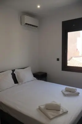 a bedroom with a bed with two towels on it at Athenean Porto Piraeus Suites -A1 in Piraeus