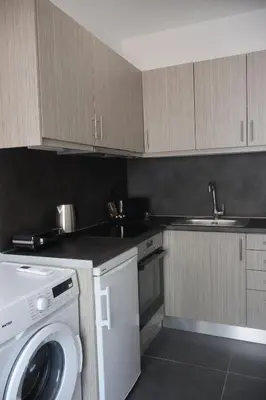 a kitchen with a washing machine and a sink at Athenean Porto Piraeus Suites -A1 in Piraeus