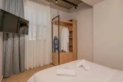 a bedroom with a bed with a television and towels at Minimal Style Apartment in Piraeus
