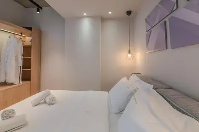 a bedroom with a white bed and a closet at Minimal Style Apartment in Piraeus