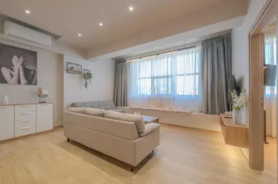 a living room with a couch and a tv and a window at Minimal Style Apartment in Piraeus
