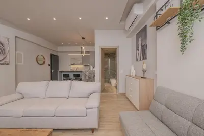 a living room with a couch and a kitchen at Minimal Style Apartment in Piraeus
